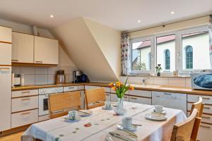 une cuisine avec une table et des fleurs dans un vase dans l'établissement Haus Eiche, à Hödingen