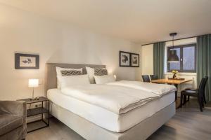 une chambre avec un grand lit blanc et un bureau dans l'établissement 1 Zimmer-appartement Nr 15, à Wangen im Allgäu