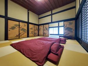a bedroom with a large bed in front of windows at 農家体験民宿 古民家 薄衣 in Ichinoseki +73 photos