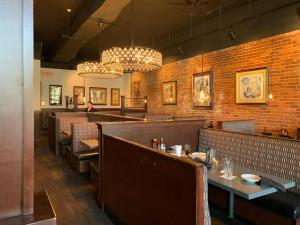 a restaurant with tables and chairs and a brick wall at Little Sunshine in Ocala