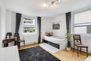 a bedroom with a bed and two chairs and a window at Haus No 6 in Lahr