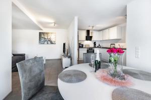 a kitchen and dining room with a white table and chairs at Schmuckstückchen in Hilzingen +16 photos