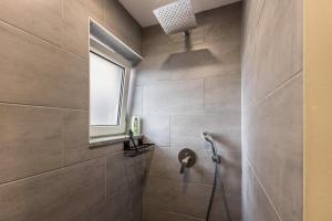 La salle de bains est pourvue d'une douche avec une fenêtre et un pommeau de douche. dans l'établissement Traumwohnung Radolfzell am Bodensee, à Radolfzell am Bodensee 13 autres photos