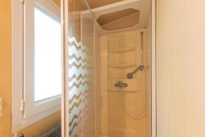 a shower in a bathroom with a window at Camping Midi - mobil home 4-6 pers in Vallon-Pont-dʼArc +9 photos
