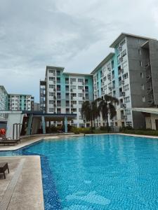 a large swimming pool in front of some buildings at 90's Themed 2 Bedroom Unit at Seawind Sasa, Davao City Philippines in Sampong +8 photos