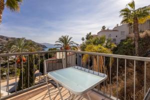 un balcon avec une table et une vue sur l'océan dans l'établissement Villa Fuentes, à Almuñécar