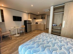 a small room with a bed and a kitchen at Maho Escape- with Pool and Gym, Lagoon view, walk to Maho Beach and Mullet Bay, walk to dinning in Maho Reef