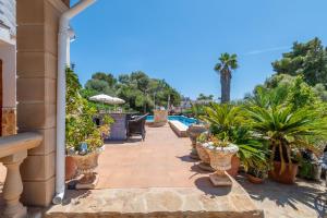eine Terrasse mit Topfpflanzen und einem Pool in der Unterkunft Villa Juana Maria in Cala Murada