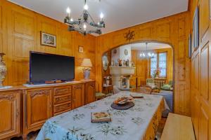 a living room with wooden walls and a tv and a table at Maison dans le centre historique in Terrasson-Lavilledieu