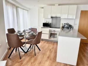 a kitchen with a table and chairs in a room at Luxury 2-Bed 2-Bath Penthouse with Terrace in Harrow