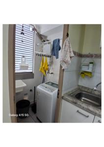 a small kitchen with a sink and a washing machine at Aires in La Serena