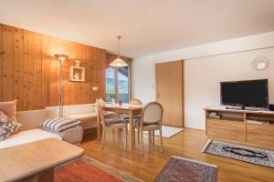 a living room with a table and a tv at Försterhaus Wohnung Dachgeschoss in Egg