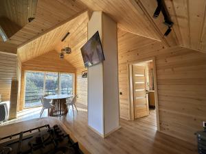 a kitchen and dining room of a wooden house at Lemko Lodge in Novyy Kropivnik