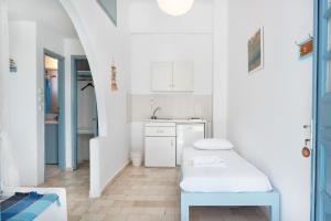 a white kitchen with a bench and a sink at Beachfront Lampis Dolphin 4 in Skala