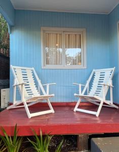 two lounge chairs sitting on a porch of a house at Casa Prusia, tipica de pioneros europeos in Aristóbulo del Valle