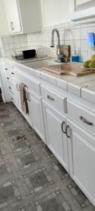 a kitchen with white cabinets and a sink at Casa Castillo 2 in La Puente