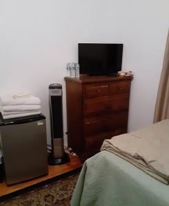 a bedroom with a bed and a dresser with a television at Casa Castillo 2 in La Puente