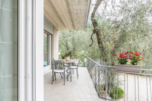 Un patio con una mesa y sillas en un balcón. en appartamento casa stefi n1, en Malcesine