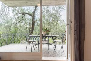 una puerta de cristal que da a un patio con mesa y sillas en appartamento casa stefi n1, en Malcesine
