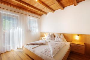 Un dormitorio con una cama y una ventana grande. en Speckign Apartment 2, en Cadipietra