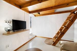 a living room with a tv and a staircase at Obispo Rancés 12 A in Chiclana de la Frontera