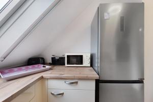 a kitchen with a refrigerator and a microwave at 3 Raum Ferienwohnung Im 1 Og in Cuxhaven
