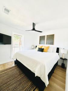 a white bedroom with a large bed and a ceiling fan at Modern & Cozy house with pool in The Colony