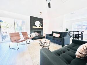 a living room with a couch and chairs and a fireplace at Modern & Cozy house with pool in The Colony