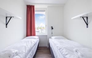 two beds in a room with a window at Saskerlei in Uitgeest