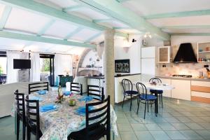 une cuisine et une salle à manger avec une table et des chaises dans l'établissement Villa Vanessa, à Punta Molara
