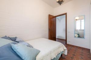 a bedroom with a bed and a mirror at Casa Nicoleup in Porto Columbu - Perdʼe Sali
