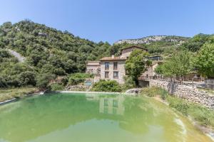 a large pool of green water in front of a building at Panoramico in Oden