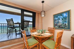 a dining room with a table and chairs and a balcony at Kaleialoha 309 · KA 309 Oceanfront Condo AC Ocean Views Heated P in Kahana