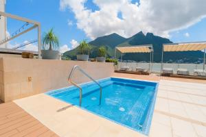 a swimming pool on the roof of a building with mountains at Moderno Ubicacion Vistas Seguridad y Estilo in Monterrey