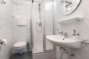a bathroom with a toilet and a sink and a shower at Mayr Apartments Eins in Plaus +18 photos