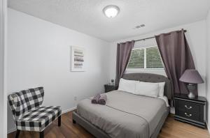 a bedroom with a bed and a chair and a window at The Cozy Rustic Sequoia Wi-Fi & 2 Garage in Tulare