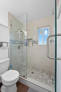 a bathroom with a shower and a toilet at The Cozy Rustic Sequoia Wi-Fi & 2 Garage in Tulare +32 photos