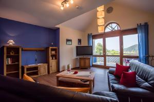 a living room with a couch and a large window at Ferienwohnung Echle in Oberharmersbach