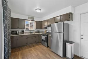 a kitchen with stainless steel appliances and wooden cabinets at The Cozy Rustic Sequoia Wi-Fi & 2 Garage in Tulare