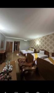 a hotel room with two beds and a table and chairs at RatanakCity hotel in Banlung