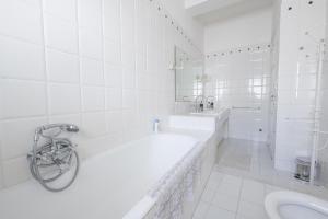 une salle de bain blanche avec une baignoire et un lavabo dans l'établissement Treviso 4, à Reggio de Calabre