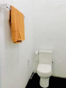 a bathroom with a toilet with an orange towel at S97 Weligama in Weligama