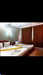 two beds in a hotel room with two at RatanakCity hotel in Banlung +2 photos