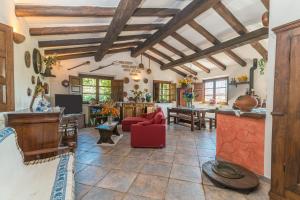 a living room with wooden ceilings and a red chair at Stazzu La Piredda in Arzachena