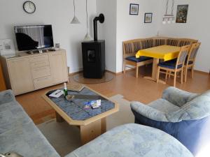 a living room with a coffee table and a tv at 3 Sterne Gästehaus Zollerblick in Zimmern