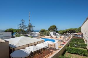 a view of a pool with umbrellas and a resort at Apartamento En Los Caños De Meca in Los Caños de Meca