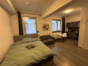 a bedroom with a bed and a living room at City Apartment Bochum in Bochum