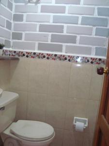 baño con aseo y pared de ladrillo blanco en Full house, 