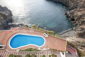 an aerial view of a swimming pool next to the ocean at Apartamento Sarai in Icod de los Vinos