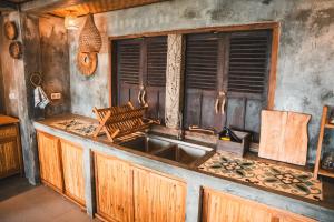 a kitchen counter with a sink and a window at Batu Kayu Medewi in Medewi +109 photos